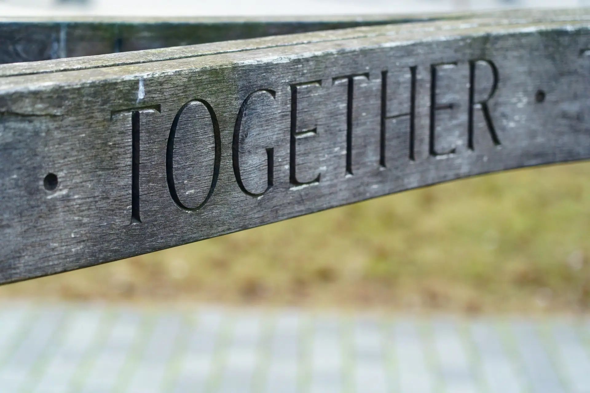 "together" carved into a wooden slat
