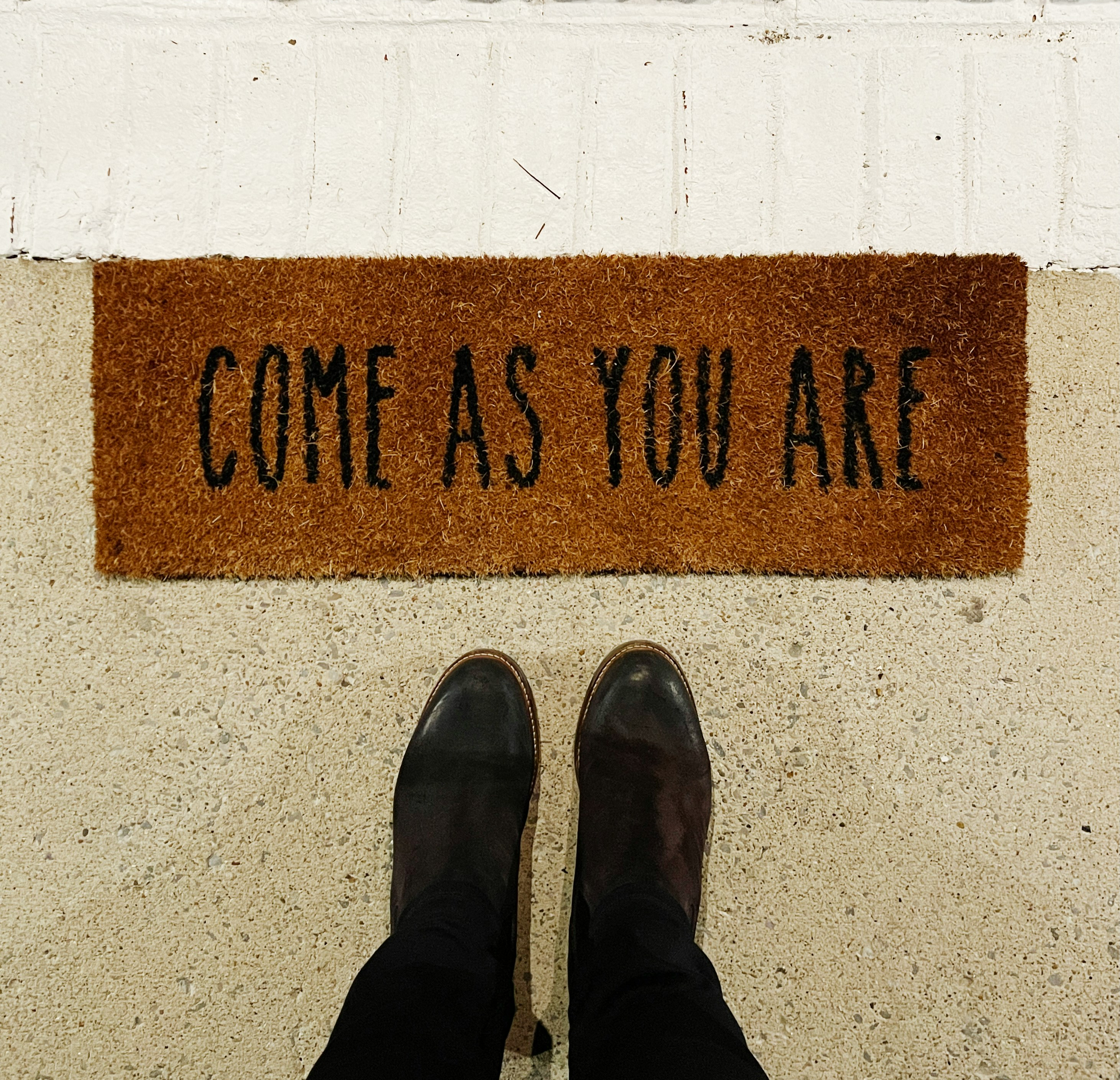 A brown door mat with the words "come as your are"