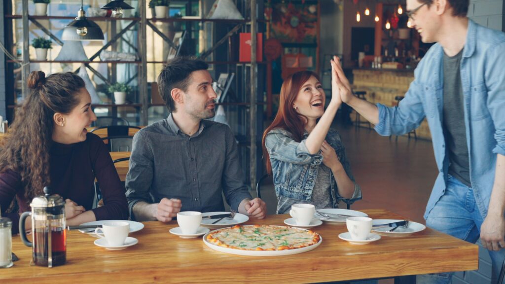 A group of people share a meal around a wooden table